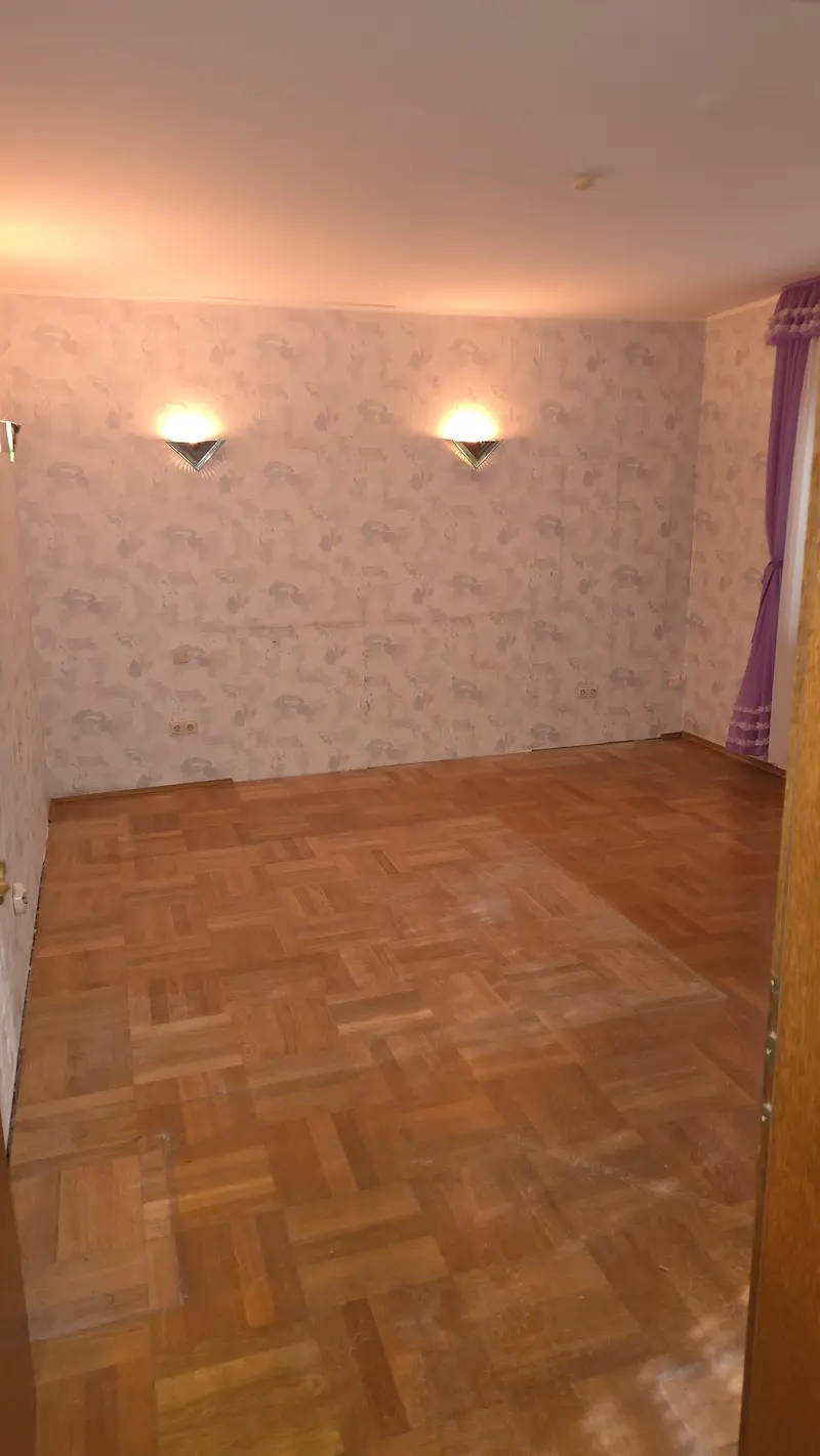 Leeres Zimmer mit Parkettboden nach der Entrümpelung